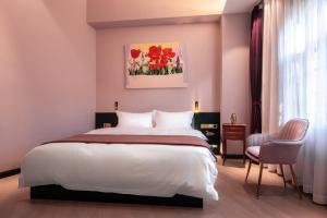 a bedroom with a large white bed and a window at Moon and Chalice Boutique Hotel in Kunming