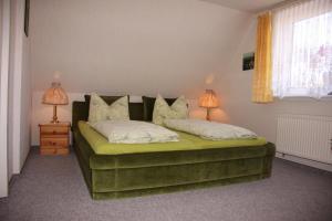 アルテンアウにあるHarz-Sonneのベッドルーム1室(緑色のベッド1台、ランプ2つ付)