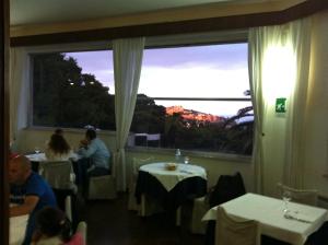 a restaurant with people sitting at tables and a large window at Hotel Eden in San Domino