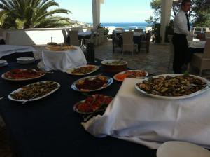 a table with many plates of food on it at Hotel Eden in San Domino