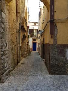 an alley with a blue door in a building at La Dimora di Ares in Formia