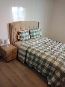 een bed met een geruite deken en een nachtkastje bij Studio Five Stars Miramar Mohammedia in Mohammedia