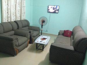 a living room with two chairs and a fan at Hotel Marie Antoinette Kara in Kara