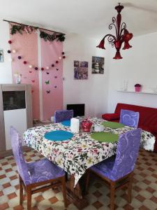 Un comedor con una mesa y sillas moradas. en Quo Vadis Qui Vieni, en Rovigo