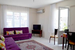 a living room with a purple couch and a tv at Ahmeda Apart Hotel in Ayvalık