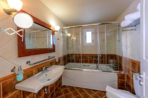 a bathroom with a bath tub and a sink at Chora Resort Hotel & Spa in Chora Folegandros