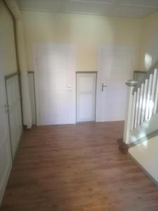 ein leeres Zimmer mit drei Türen und einer Treppe in der Unterkunft Auestraße 94A in Glauchau