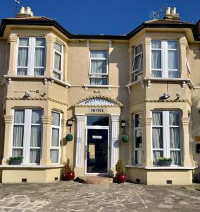 une grande maison jaune avec une porte d'entrée dans l'établissement Britannia Inn Hotel, à Ilford