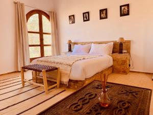 una camera con un grande letto e una finestra di Kasbah Isfoula and Spa a Aït Ben Haddou