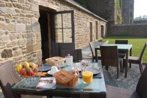 a table with food and fruit on a patio at Maison d'hôtes & Gîtes Domaine de la Garaye in Dinan