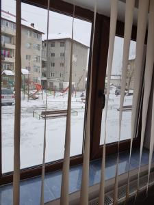 a window with a view of a snow covered field at Apartament Mioritza 2A in Horezu