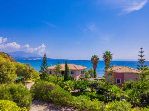 een huis met de oceaan op de achtergrond bij Kounopetra Beach Luxury Villas in Kounopetra