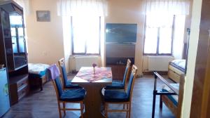 a dining room with a table and chairs and windows at Penzion SKLAŘSKÁ HOSPODA in Chřibská