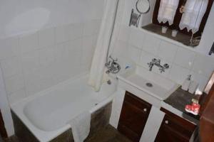 y baño blanco con lavabo, bañera y lavamanos. en Traditional Greek Cottage, en Palaiókastron