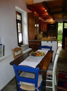 a kitchen with a table with a bowl of fruit on it at Traditional Greek Cottage in Palaiókastron