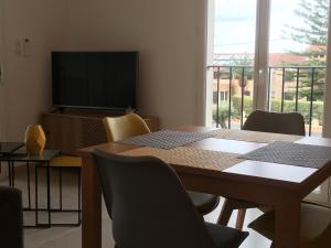 a dining room with a table and a television at RESIDENCE A MORTELLA - LIEU DIT TETTOLA in Saint-Florent