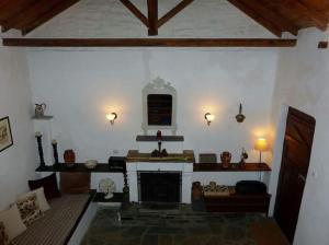 una sala de estar con chimenea en una casa en Traditional Greek Cottage, en Palaiókastron