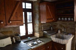 Palaiókastron的住宿－Traditional Greek Cottage，厨房配有木制橱柜和炉灶烤箱。