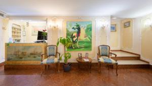 una habitación con 2 sillas, una mesa y una pintura en Hotel San Giorgio, en Venecia