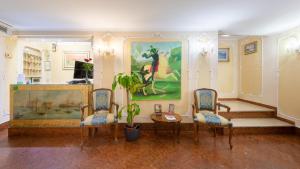 a room with two chairs and a table and a painting at Hotel San Giorgio in Venice
