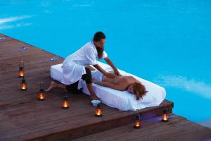 a man and a woman on a bed next to a pool at Chora Resort Hotel & Spa in Chora Folegandros