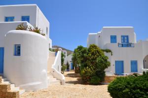 a row of white buildings with blue windows at Chora Resort Hotel & Spa in Chora Folegandros