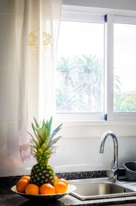 um ananás num prato num balcão ao lado de um lavatório em Casa En La Playa Del Rey em Mareny Barraquetas