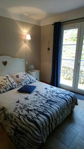 a bedroom with a bed and a large window at B&B La Boissière Et Le Vialat in Montagnac