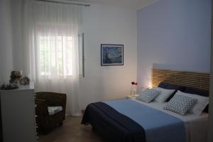 ein Schlafzimmer mit einem Bett, einem Stuhl und einem Fenster in der Unterkunft Villa Sun Beach in Torre Lapillo