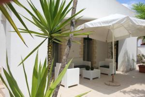 eine Terrasse mit einer Palme und einem Sonnenschirm in der Unterkunft Villa Sun Beach in Torre Lapillo