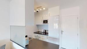 a kitchen with white cabinets and a refrigerator at Amadores Sunset Suite in Amadores