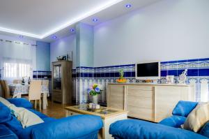 a living room with two blue couches and a tv at Casa Pescadores de Vallterra in El Palmar