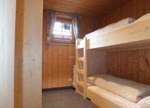 2 Etagenbetten in einem Blockhaus mit einem Fenster in der Unterkunft Hüttenzeit almhütte sölden in Sölden