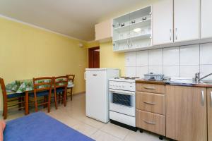 a kitchen with a white refrigerator and a table at Apartments Posavec in Pinezici