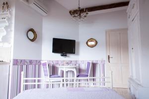 a bedroom with a white crib and a tv on the wall at Apartments Authentic Baska in Baška