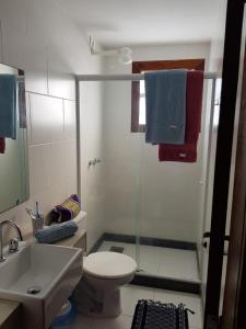 uma casa de banho com um chuveiro, um WC e um lavatório. em Búzios Lofts em Búzios
