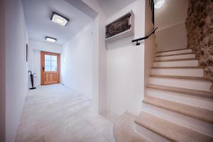 un pasillo con escaleras en una casa con paredes blancas en Demaria apartman u Komiži s pogledom na more en Komiža