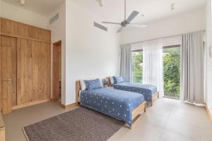 a bedroom with two blue beds and a window at AquaBlu Villa in Victoria