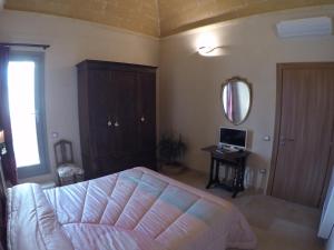 a bedroom with a bed and a table and a mirror at Signorino Suites&Pool in Marsala