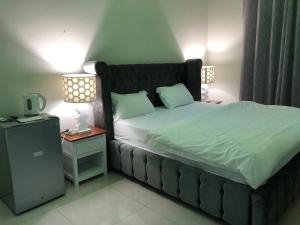 a bedroom with a large bed and a night stand at Tafadal in Ibrā