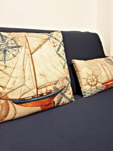 a bed with two pillows with a boat on it at Chalet Tiziana ~ Una veranda sul mare ~ in Messina