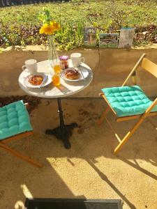 un tavolo con piatti e due sedie di Grand Vue Vert a Roubert