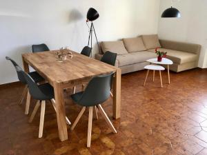 een woonkamer met een houten tafel en stoelen bij Casa Micheroli Parterre in Gordola