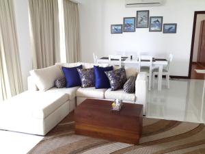 a living room with a white couch and blue pillows at LLH 321 Nilaveli Ocean Front Condos in Nilaveli