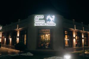 a building with a lit up sign in the night at Cruce de Gustos in Ivano-Frankivsʼk