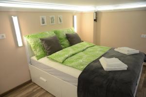 a bedroom with a large bed with green sheets at Green Island in the downtown with free parking in Debrecen