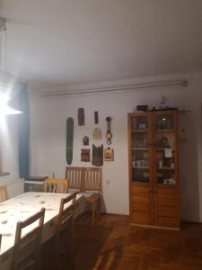 a dining room with a table and a wooden cabinet at Zsigmond Ház in Poroszló
