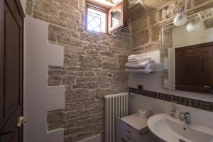 a bathroom with a sink and a stone wall at MASSERIA CITULO Il Pino grande in Castel del Monte