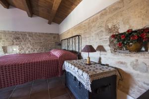 een slaapkamer met een bed en een tafel met een lamp bij MASSERIA CITULO Il Pino grande in Castel del Monte