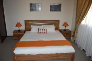 1 dormitorio con 1 cama grande y 2 lámparas en las mesas en Motebong Lodge, en Bokong